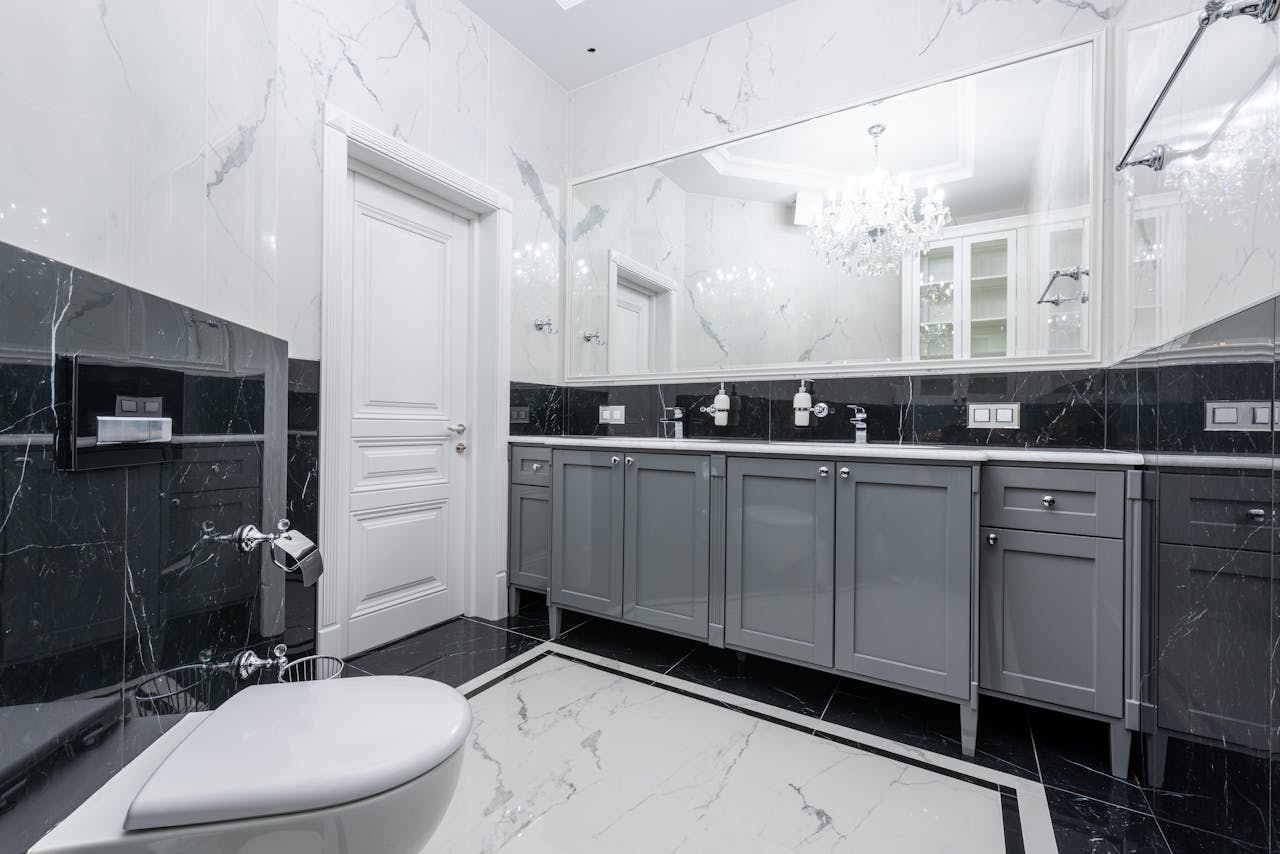 Prestige bathroom with large mirror and glowing chandelier