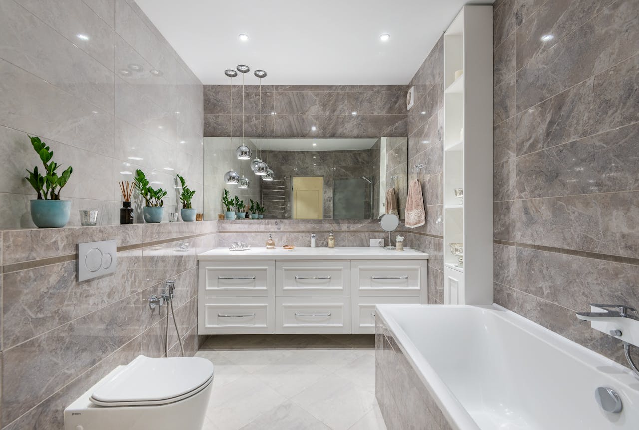 Spacious bathroom with bathtub and mirror hanging over white cupboard